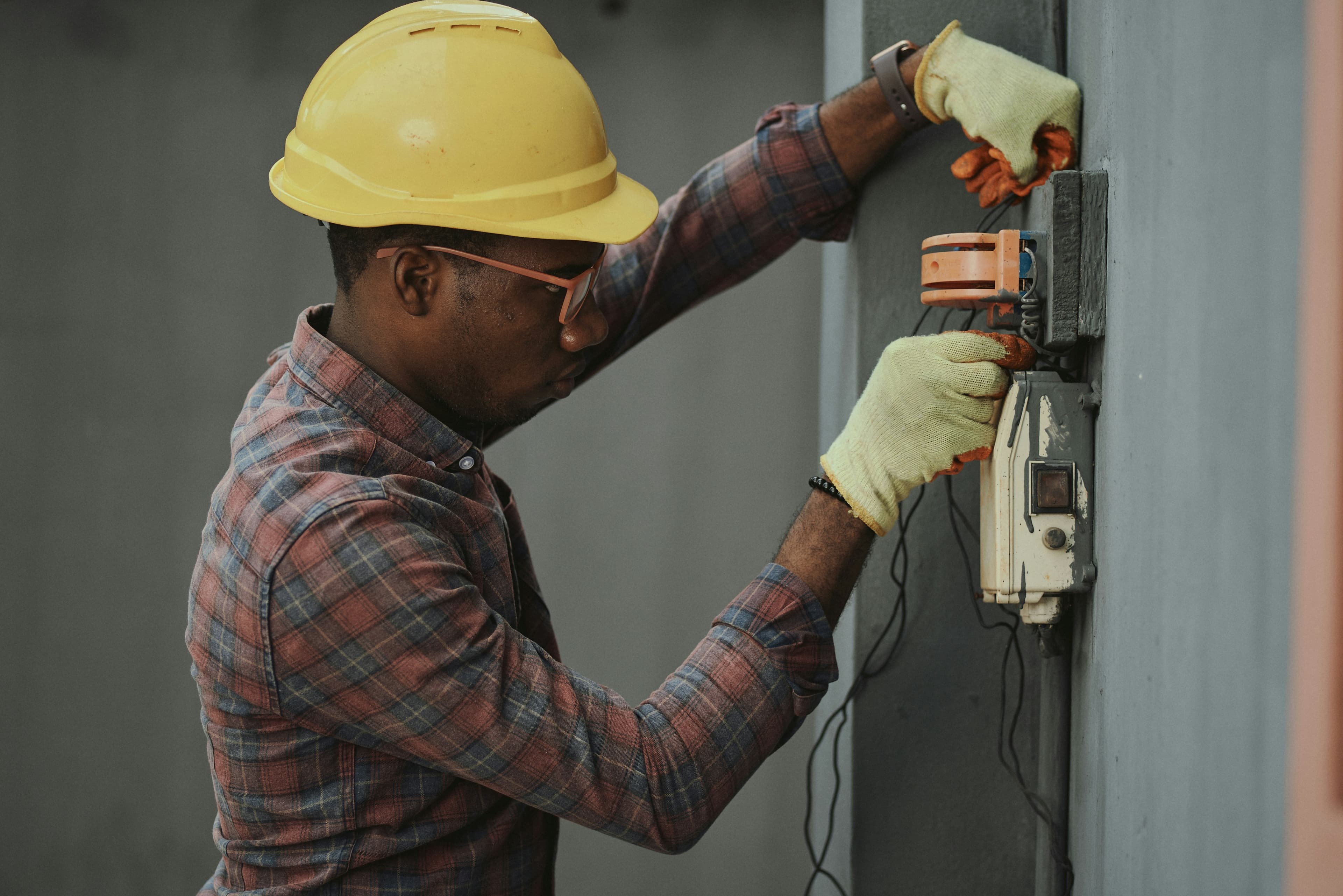 Man in brown hat holding black and gray power tool